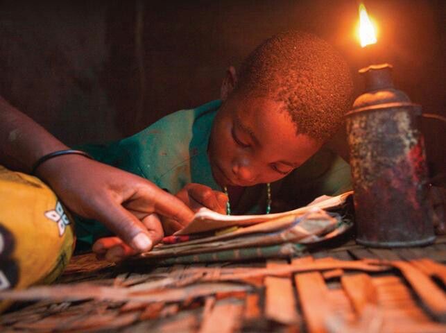 Child studying by lamplight